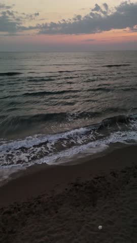 fpv drone flies low over the water of a large lake against the background of the setting sun fast flight over the water waves reflect the sunset evening. High quality 4k footage nobody towards the sun