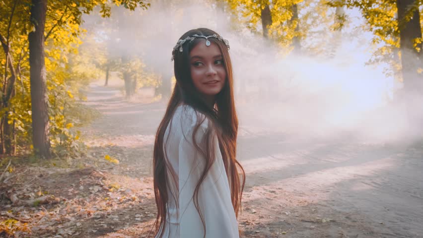 Fantasy woman queen running in autumn forest fog mist backlit Sun sunset orange color trees foliage. lady in long white silk dress fabric flying in wind. Girl elf goddess back rear view. Slow motion.