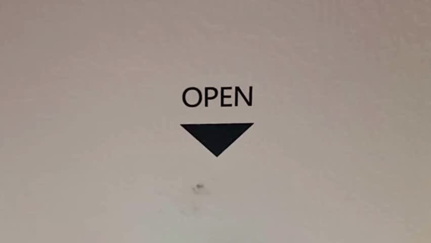 Minimalist close up shot of the word OPEN with downward arrow printed on surface, neutral background, no face. Useful for design, interface, instruction, or packaging concept.