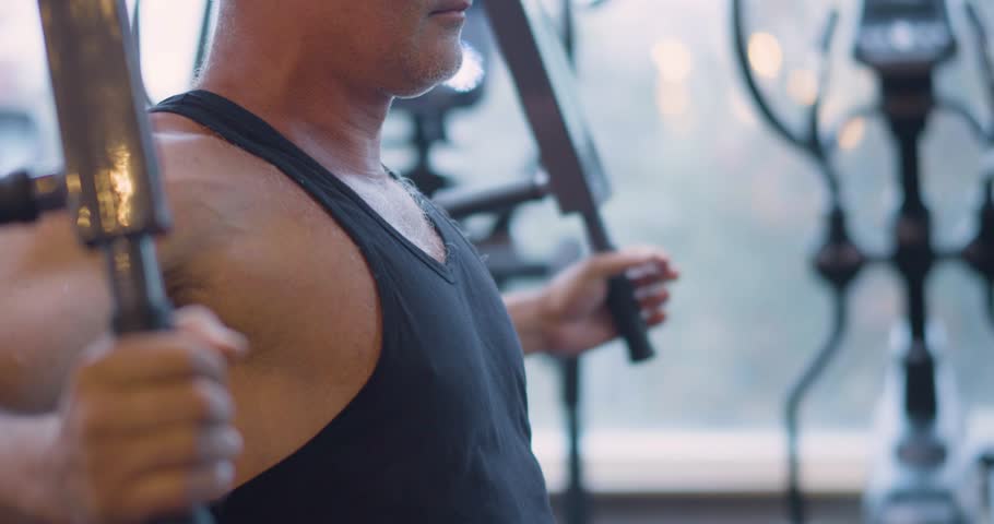 Gym workout. Butterfly exercise. Middle aged Caucasian man trains his pectoral muscles in the gym. Gym workout shows man targeting pectorals through butterfly machine exercise.