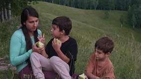 Mother and children eating green apples in a beautiful natural landscape - Powered by Shutterstock - Get 15% off with code: PIKWIZARD15