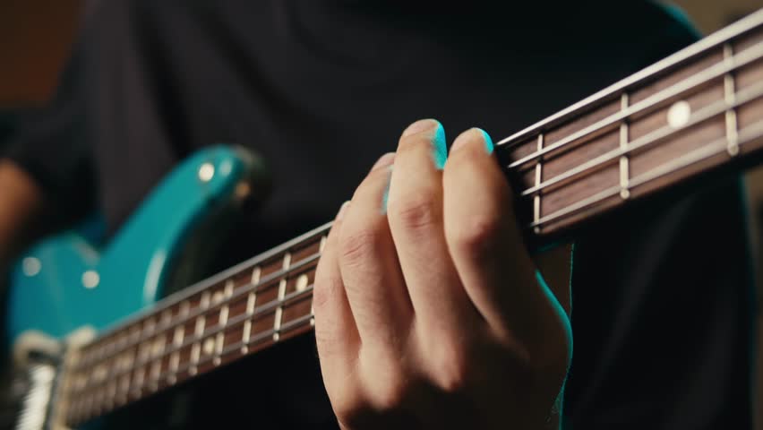 Bass guitar being played in a recording studio, rehearsal room, man playing jazz close up macro, vintage recording equipment