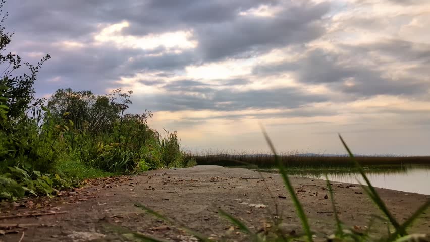 Man Riding Mountain Bike on Countryside pier Near Lake Under Cloudy Sky, sport and activities, lifestyle, freedom