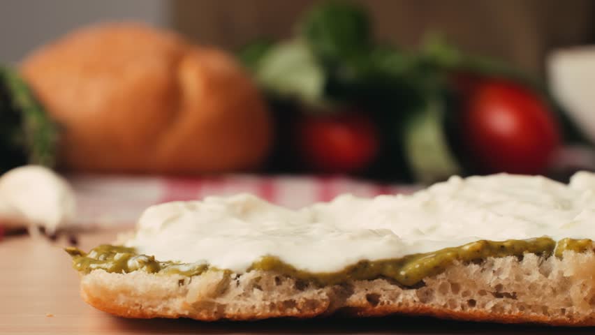 Mortadella ham sandwich, Traditional italian focaccia filled with thin pesto slices of mortadella, served by chef man in cafe restaurant. Macro of traditional italian spanish tapas antipasti. 