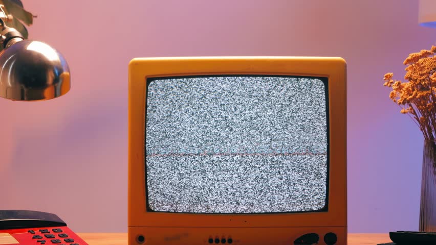 Retro TV, vintage television In a nostalgic setup, a retro TV displays grain on screen, scary halloween night device good for chroma key and green screen.