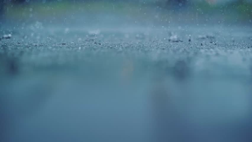 Slow motion rain splashes in upper third while blurred surface adds depth calm