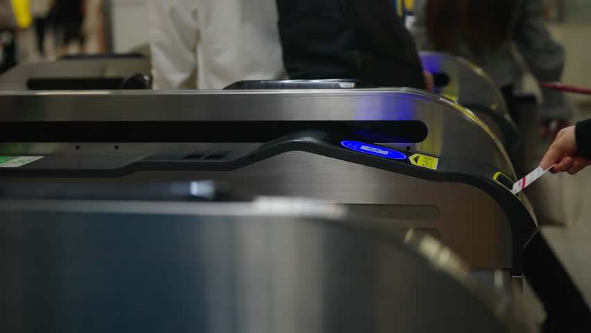 Passenger tap ic card or smartphone on auto gate making payment for public transportation at subway station in city. Crowd of People walking pass turnstile gate in subway station in rush hour morning.