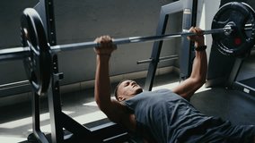 A man engaging in a bench press workout at the gym. He is lifting heavy weights for strength training, promoting fitness and muscle growth. Dedication and effort shown in his expression. - Powered by Shutterstock - Get 15% off with code: PIKWIZARD15