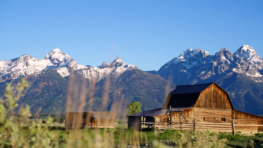 Pan of Mormon Row and Moulton Barn in Grand Teton National Park, Wyoming near sunrise.