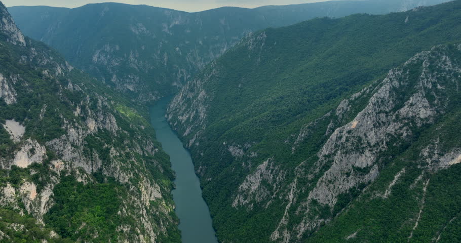 A river runs through a canyon The aerial view of a canyon walls have green trees and rock formations