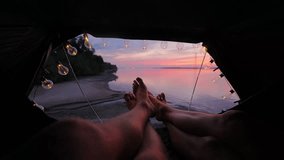 Two people relax, rooftop tent at sunset, warm bulb lights, romantic river view - Powered by Shutterstock - Get 15% off with code: PIKWIZARD15