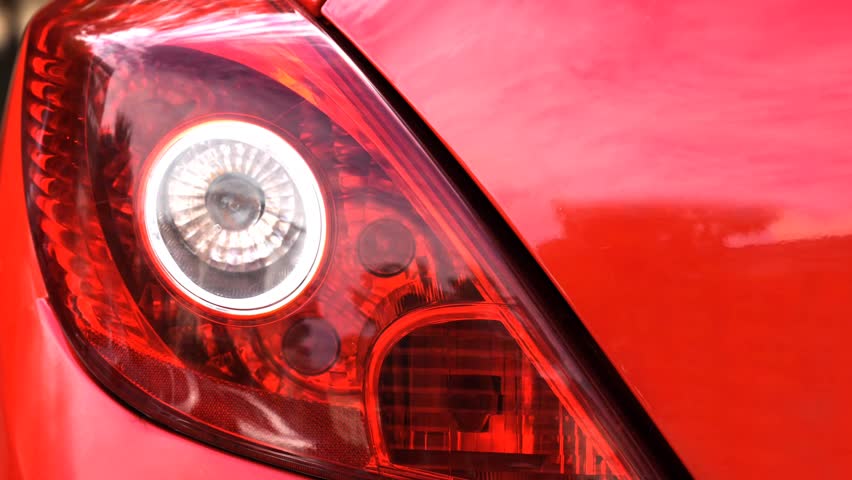 Seamless loop animation slideshow of car headlight brake light urban street background backdrop. Close up of a car.	Zoom in, zoom out.
