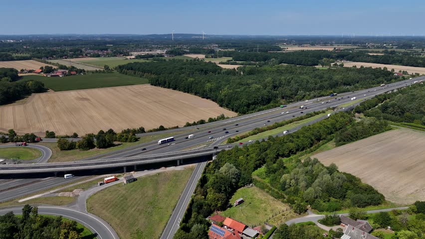 Traffic on multi-Land highway in American suburb. Rural landscape during sunny days with blue sky. Aerial forward wide shot. Cars and vehicles on expressway in Wisconsin.