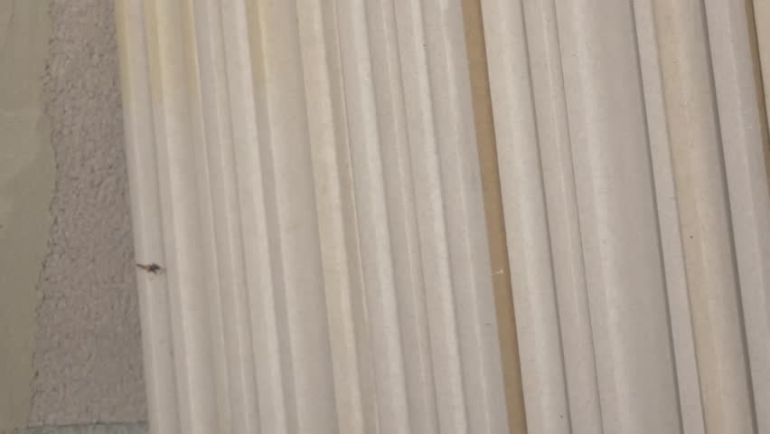 Stack of drywall sheets displayed in a structured manner, highlighting surface textures and color differences, illustrating construction material arrangement. stack of dry wall 