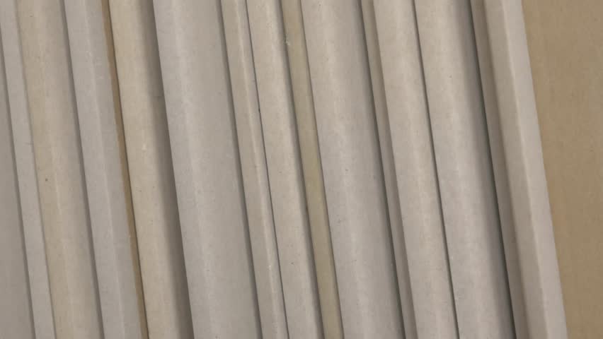 Stack of drywall sheets displayed in a structured manner, highlighting surface textures and color differences, illustrating construction material arrangement. stack of dry wall 