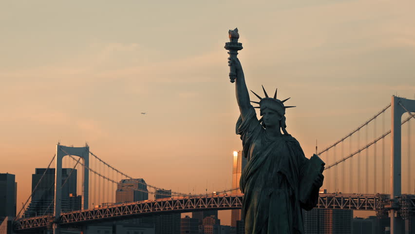 Statue of Liberty Replica with Rainbow Bridge and Tokyo Skyline at Sunset