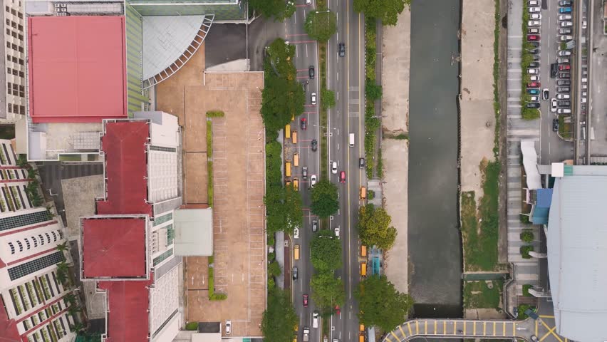 Top-down drone shot of Kuala Lumpur, Malaysia, revealing downtown streets, traffic, river, and urban structures in a bustling city environment.