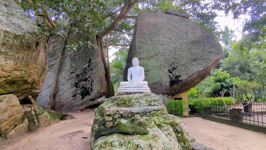 Religious buddhist statue with large spilt rock located at Yapahuwa Rock Fortress in Sri Lanka
