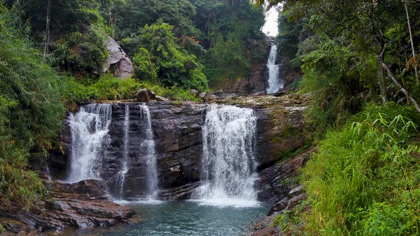 Fast flowing Kadiyanlena falls cascading three tier waterfall on Mahaweli river in Kandy District of Sri Lanka