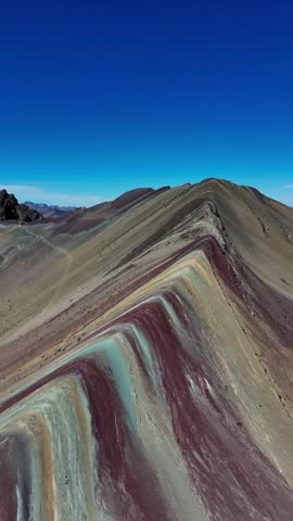 A vertical aerial footage of Rainbow Mountain, also known as Vinicunca or Montana de Siete Colores in the Peruvian Andes, located in the Cusco region