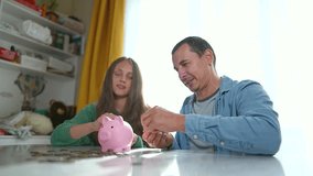 Family finance planning. Father and daughter saving coins in piggybank. Family counting coins together, learning about finance. Piggybank symbolizes family savings. Financial literacy in action. - Powered by Shutterstock - Get 15% off with code: PIKWIZARD15