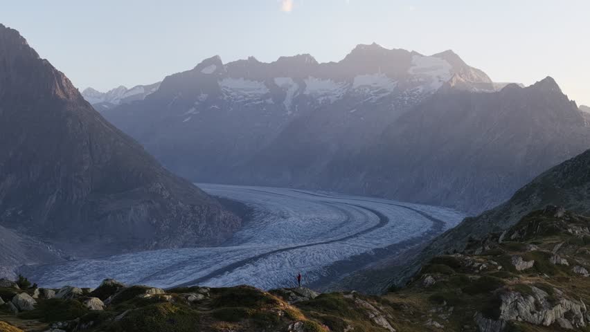 Aerial view of the Aletsch Glacier snakes through the rugged landscape, nestled between towering mountains, Fieschertal, Valais, Switzerland.