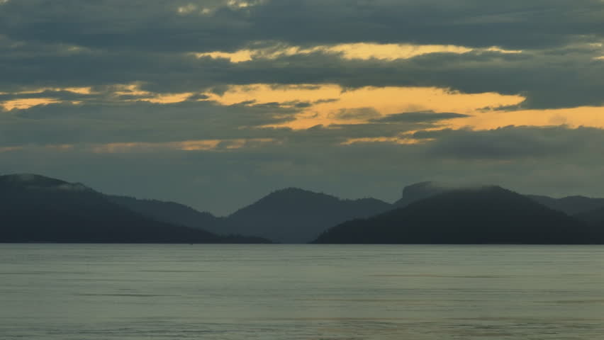 Long lens drone shot of the silhouetted Whitsunday Islands during the sunrise, Australia