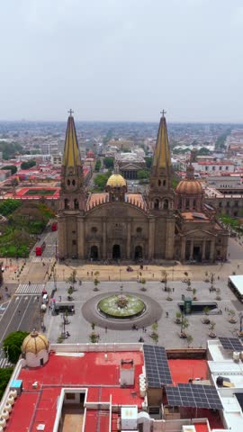 Drone aerial of Guadalajara Cathedral with twin towers, dome, and fountain in main plaza, Jalisco, Mexico. Vertical shot