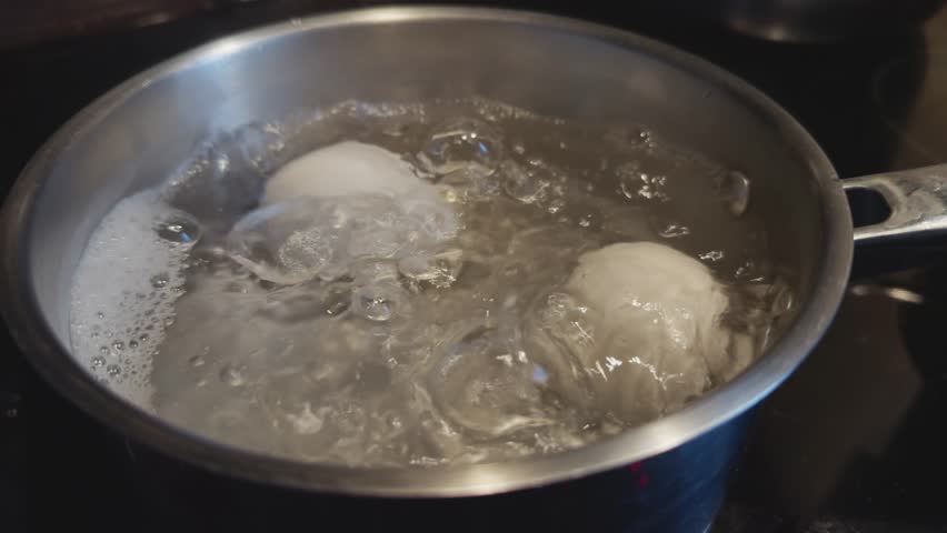 Eggs Boiling In Glass Pot For Easter. Breakfast Healthy Food. Chicken Eggs Boiled In Boiling Water On Stove. Protein Nutrition. Saucepan With Boiled Egg For Easter. Diet Breakfast Soft-Boiled Eggs Eat