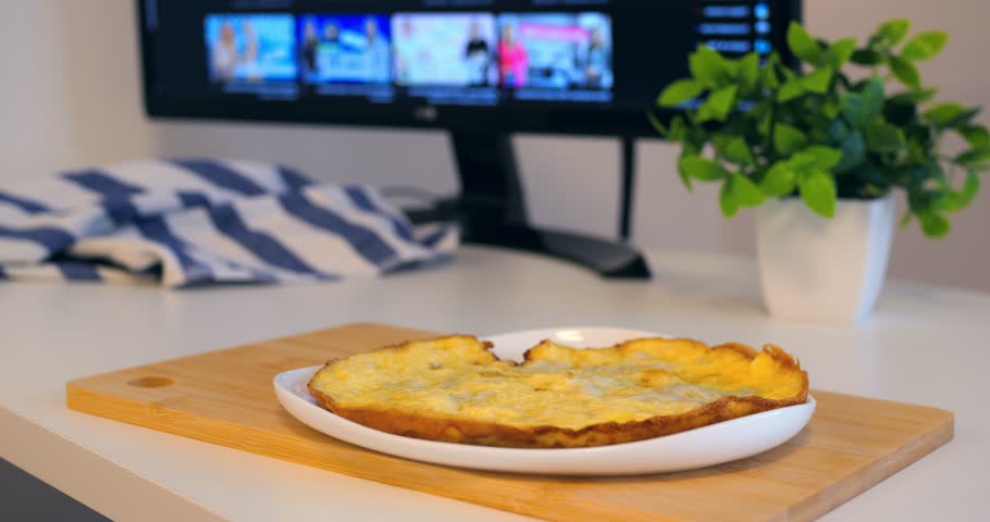 Omelette on plate with black mug on desk, breakfast served near monitor, casual work from home setup, cozy lifestyle mood, omelette repeated twice for theme, simple meal scene, brunch feel, omelette