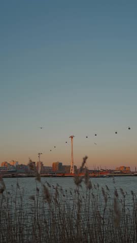 vertical video of a sunset over the Thames River overlooking the cable cars at IFS royal docks in london