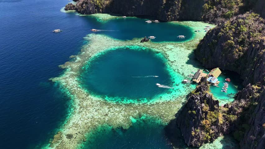 Aerial perspective of the stunning Twin Lagoon, with turquoise waters and a few houses in Coron, Philippines