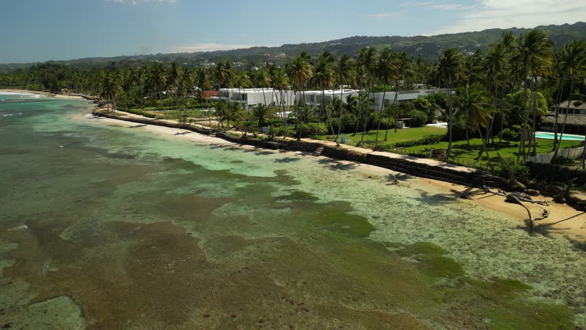 4K drone view of Playa Bonita, a Caribbean paradise with calm waters and lush palms. Great for tropical lifestyle and wellness content