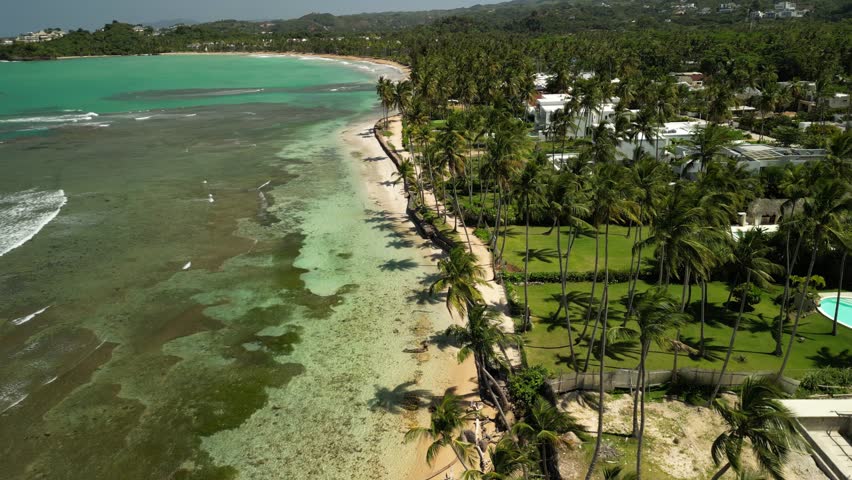 Drone footage of Playa Bonita with clear Caribbean water, palm trees, and golden sand. Ideal for eco-tourism and tropical media