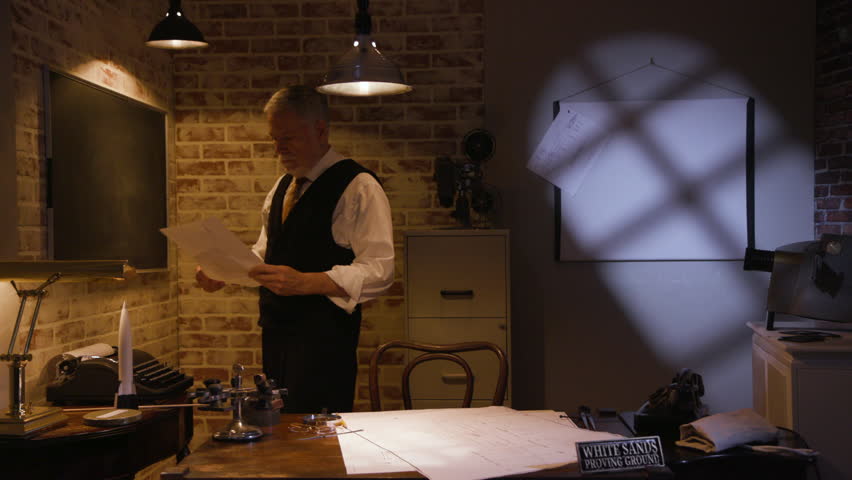 A V2 rocket engineer from the late 1940s writing a formula on a chalkboard in this office.