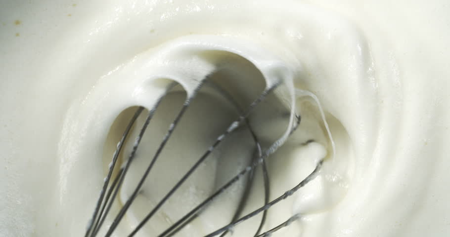 Super Slow Motion Close-Up of Whisk Mixing Smooth White Cream in Shot of Fluffy Dessert Preparation with Glossy Texture, Capturing the Whipping Motion of Sweet Ingredients for Baking or Pastry Recipes