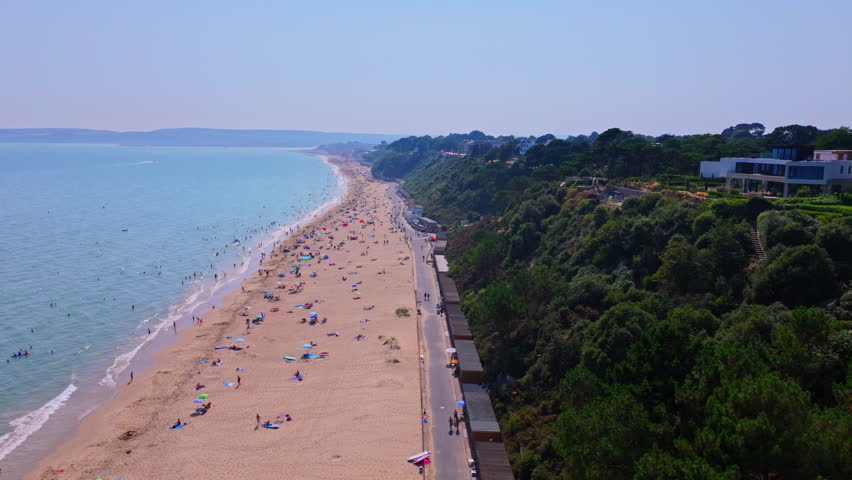 Tracking aerial shot out and away from the beach looking towards Sandbanks near Poole, Dorset, UK.
