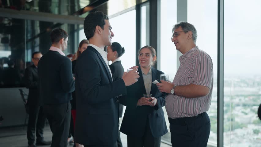 Diverse International Entrepreneurs Standing and Chatting Casually with Beverages in Hand on Tall Building Rooftop with Urban City View