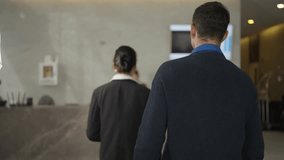 Rear View of Business Professionals Walking Together Toward Hotel Lobby Reception Desk to Check In for Corporate Meeting or Accommodation, Concept of Business Travel and Hospitality Service - Powered by Shutterstock - Get 15% off with code: PIKWIZARD15