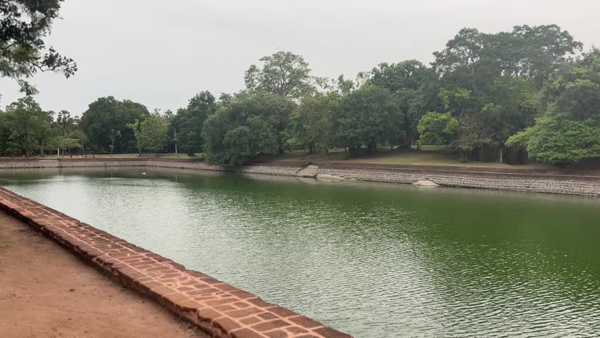 Elephant Pond serene landscape with lush greenery and historical sign, perfect for travel blogs and cultural content about Sri Lanka