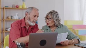 Senior couple discussing documents and using laptop in slow motion - Powered by Shutterstock - Get 15% off with code: PIKWIZARD15