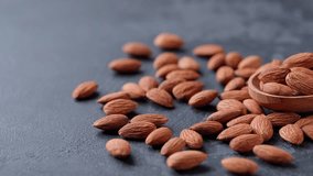 almonds in a wooden spoon on a black stone table.  Wooden spoon filled with raw almonds on a dark surface.  - Powered by Shutterstock - Get 15% off with code: PIKWIZARD15