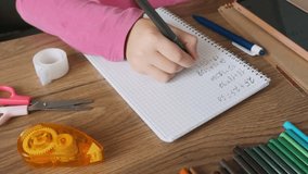 Child doing math exercises in notebook with stationery on wooden table. Girl hand writing mathematical equations as school homework. Back to school, learning, education concept - Powered by Shutterstock - Get 15% off with code: PIKWIZARD15