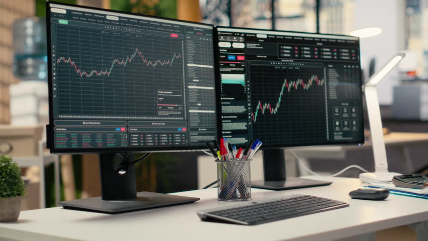 PC monitors displaying stock market candlestick charts in modern prop firm office. Trading company workspace desk setup used for stock exchange analysis and strategy planning - Powered by Shutterstock - Get 15% off with code: PIKWIZARD15