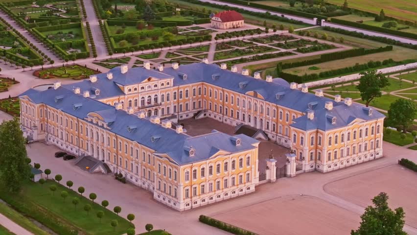 Evening drone shot of Rundale Palace surrounded by gardens and symmetry