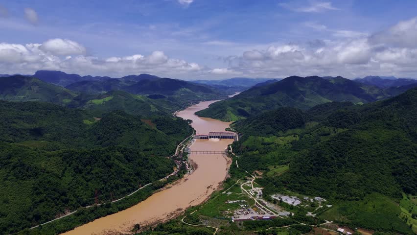 Serene River Valley Panorama: An aerial perspective captures a majestic river snaking through lush, verdant valleys under a vibrant blue sky
