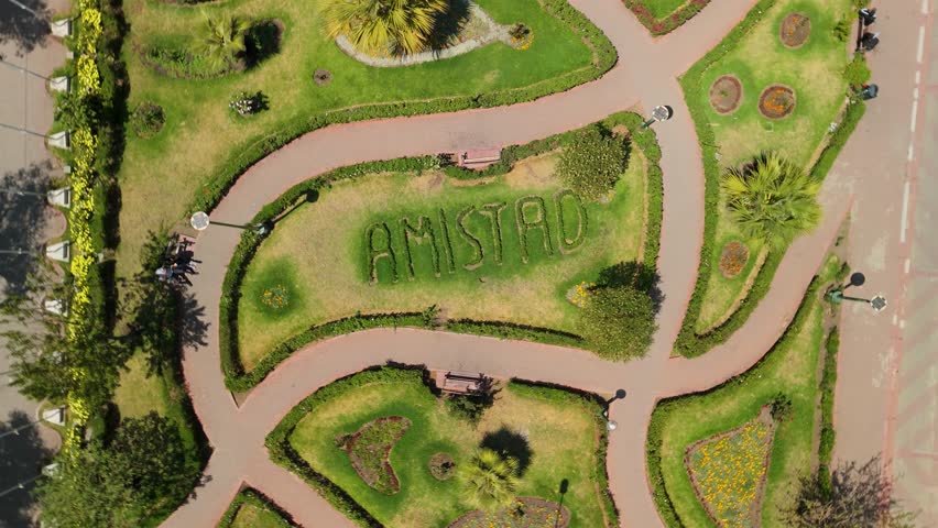 Dynamic top down aerial shot spins over the geometric patterns of Parque de la Amistad in Huaraz, creating a hypnotic spiraling birds eye view of the public park