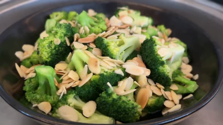 Fresh broccoli with creamy almond butter sauce drizzled over vibrant green florets