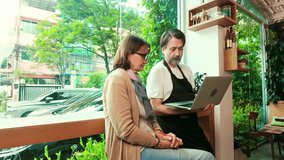 Cafe owner and financial advisor reviewing business data on smart phones inside a cozy coffee shop. Bright natural light and greenery enhance the productive and collaborative workspace atmosphere. - Powered by Shutterstock - Get 15% off with code: PIKWIZARD15