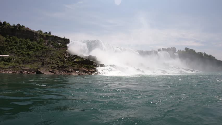 DOLLY SLOW MOTION - The Niagara Falls (American Falls and Bridal Veil Falls) seen from a boat tour on the Niagara River in Ontario, Canada.
